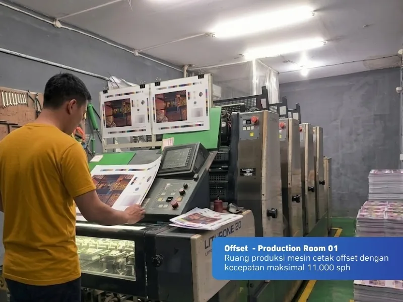 Operator memeriksa hasil cetak di mesin offset Lithrone 20 di ruang produksi